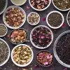 A variety of dry loose leaves in small ceramic bowls to test if tea expires over time