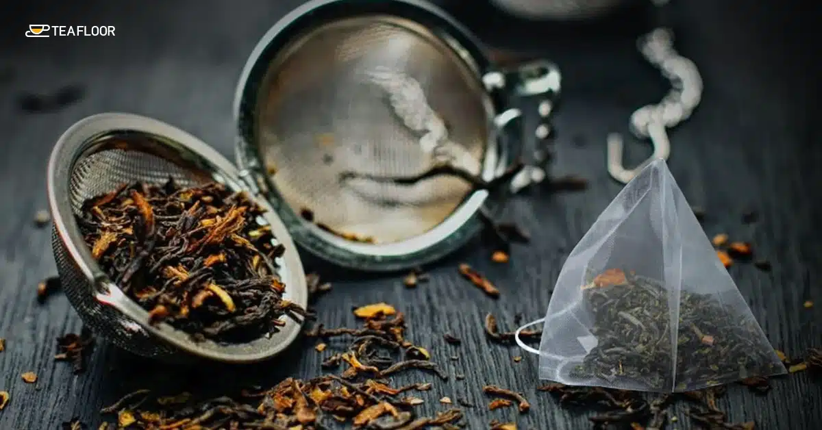 A side by side shot of black tea inside a metal mesh infuser and a single pyramid sachet to compare their freshness